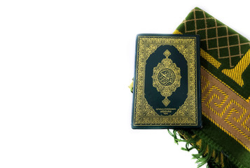 Photos of the Koran and prayer rugs ready for Ramadan.  Arabic on the cover is translated as the...