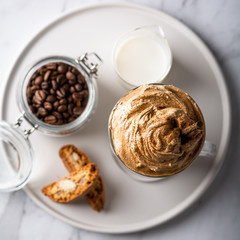 Trendy korean whipped coffee Dalgona on a licht background. 