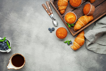 Continental breakfast captured from above (top view, flat lay). Coffee,  juice, croissants,muffins and blueberry.