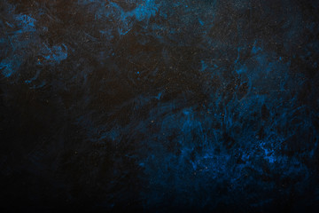 Black blue painted concrete texture or background with shadow and grain elements. High contrast and...