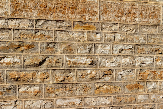 Abstract texture background of a 19th Century brown color natural limestone wall, with tuckpointing mortar restoration