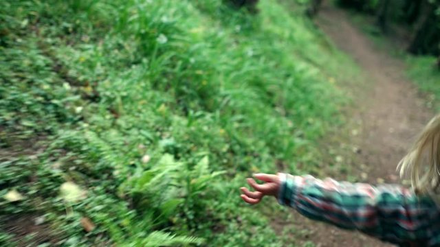 Little preschooler running in the woods with a stick
