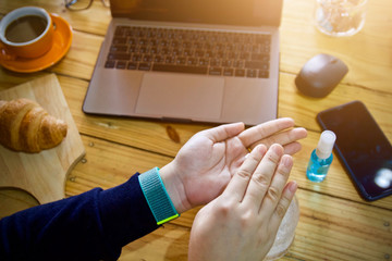 Coronavirus Business woman working from home wearing protective mask. Working from home . Cleaning her hands with sanitizer gel .