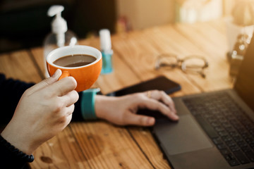 Coronavirus Business woman working from home wearing protective mask. Working from home . Cleaning her hands with sanitizer gel .