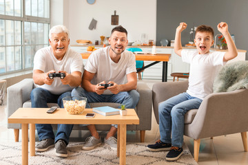 Man with his father and son playing video games at home