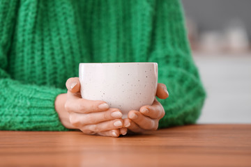 Beautiful young woman drinking tea at home, closeup