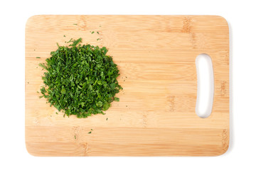 Cutting board and chopped herbs on white background with copy space