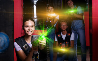 Smiling girl with laser guns  took aim and having fun with frien