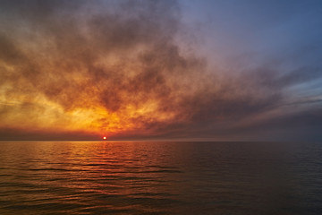 Sea sunset. Smoke wildfires sweeping across the sky.