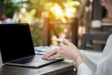 Online Shopping Website on Laptop. Easy E-commerce Website Shop by Smartphone, iPhone, iPad and Laptop. Close up Hands Using Smartphone Shopping Cart Reading Online Article, Blog.