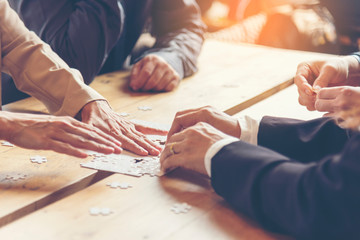 Implement improve puzzel solve connections together with synergy strategy team building organizing connection by trust communication. Hands of stakeholders business trust team holding jigsaw puzzle - obrazy, fototapety, plakaty