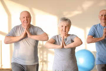 Elderly people exercising in gym