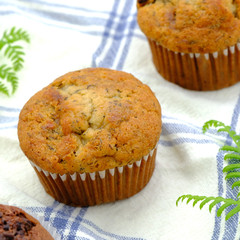 Homemade delicious chocolate muffin on wooden background close-up