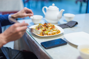 Man eating noodles in a cafe during lunch