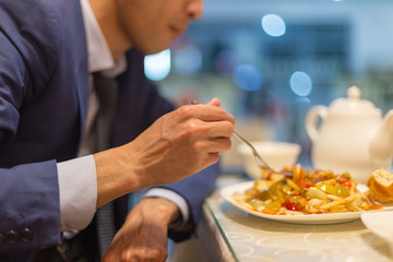 Man eating noodles in a cafe during lunch