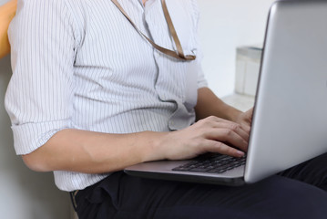 Cropped image of young business man in formal wear using laptop for his job at outside office.