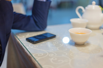 A man sits in a cafe and reads SMS