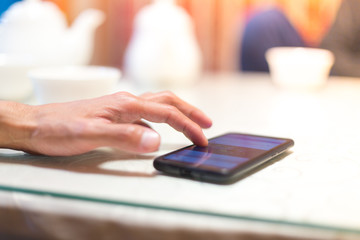 A man sits in a cafe and reads SMS
