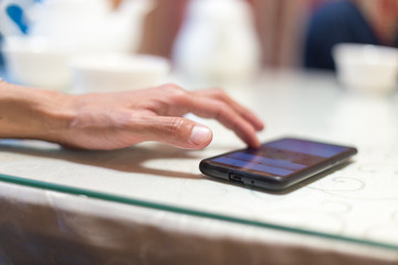 A man sits in a cafe and reads SMS