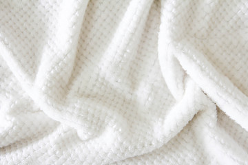 White shaggy blanket texture as background. Fluffy fake textile fur. Soft focus, Selective focus.