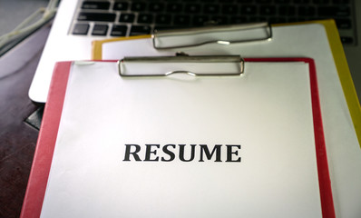 Closeup of resume on top of computer laptop on table