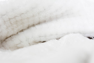 White shaggy blanket texture as background. Fluffy fake textile fur. Soft focus, Selective focus.