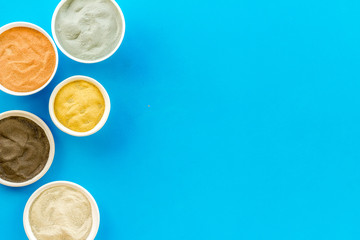 Yellow, red, white, blue and black cosmetic clay top view copy space