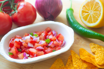 Mexican salsa pico de gallo with tomatoes, red onions, spicy green jalapeno pepper, lemon and nacho corn chips