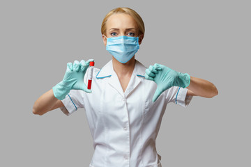 medical doctor nurse woman wearing protective mask and gloves - holding virus blood test