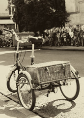 Fototapeta na wymiar Vintage photo of An old tricycle / bike with a straw basket on a street in Cambridge