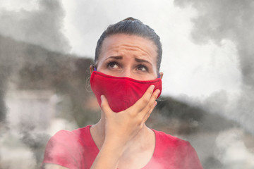 Woman in a protective red mask, among forest fires. Person in smoke or smog, shows suffocating, environmental disaster. 
