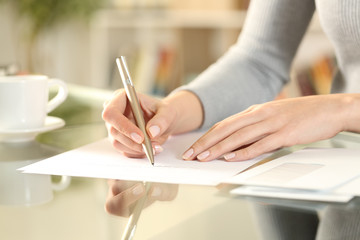 Woman hands writing a letter on a desk at home - obrazy, fototapety, plakaty
