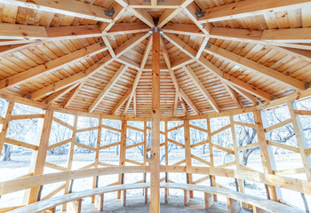 The wooden roof of the gazebo, standing on the street in the Park. Winter. Ceiling vault of wooden beams