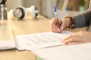 Student girl hands signing contract at home