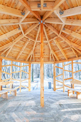 The wooden roof of the gazebo, standing on the street in the Park. Winter. Ceiling vault of wooden beams