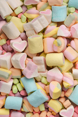 Assorted multicolor marshmallows close-up top view. A pile of different sweet marshmallows...