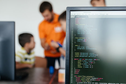 Portrait of Programmer Developer writes the source code of the software. Male worker concentrating on codes at the office. Child and laptop. Technology and computers for children.