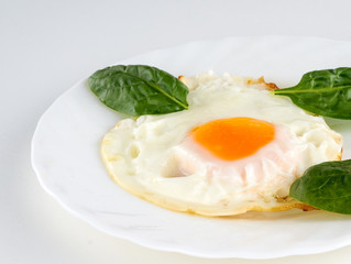 eggs with spinach on a white table