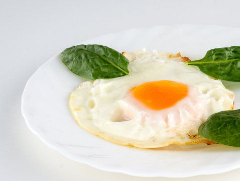 eggs with spinach on a white table