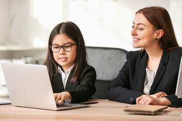 Cute little businesswoman with client in office