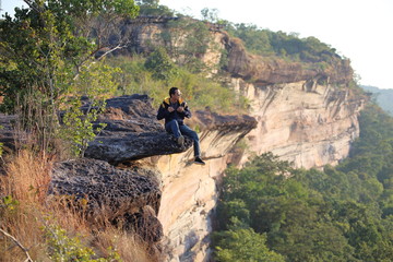 Obraz premium Man sitting on the cliff at Pha Tam National Park, Ubon Ratchathani, Thailand