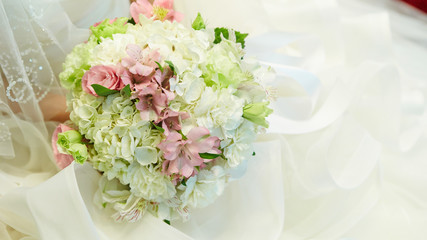 Bride in wedding dress holding flower bouquet 