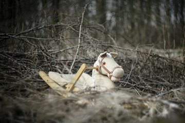 abandoned toy horse in the woods. the end of childhood