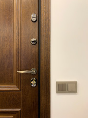 Wooden front door. Metal bronze handle. Bright interior.