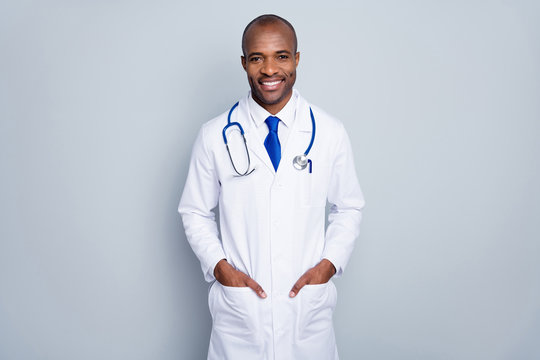 Photo of doctor handsome dark skin guy listening patient virologist family doc cheerful beaming smile wear white lab coat blue neck tie stethoscope isolated grey color background