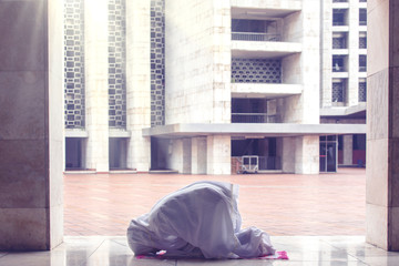 Young woman doing worship to Allah in mosque