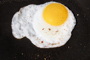 Scrambled egg on black pan background