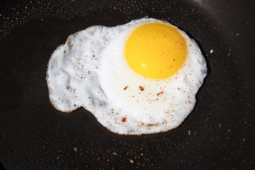 Scrambled egg on black pan background
