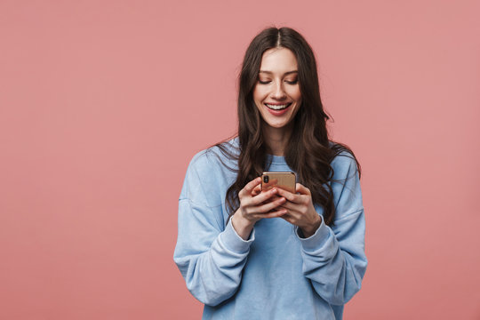 Image of happy beautiful woman smiling and using smartphone