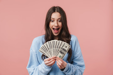 Image of attractive young woman rejoicing and holding dollar banknotes